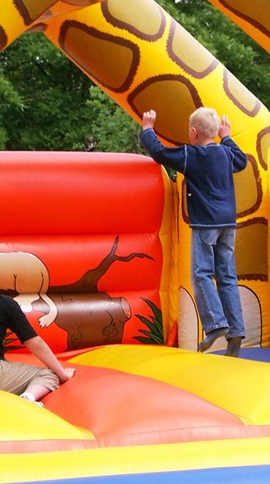 child jumping on a jiraffe shaped bounce house